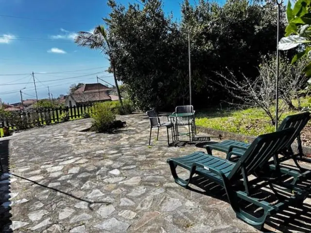 Pátio de calçada com espreguiçadeiras e o mar ao fundo